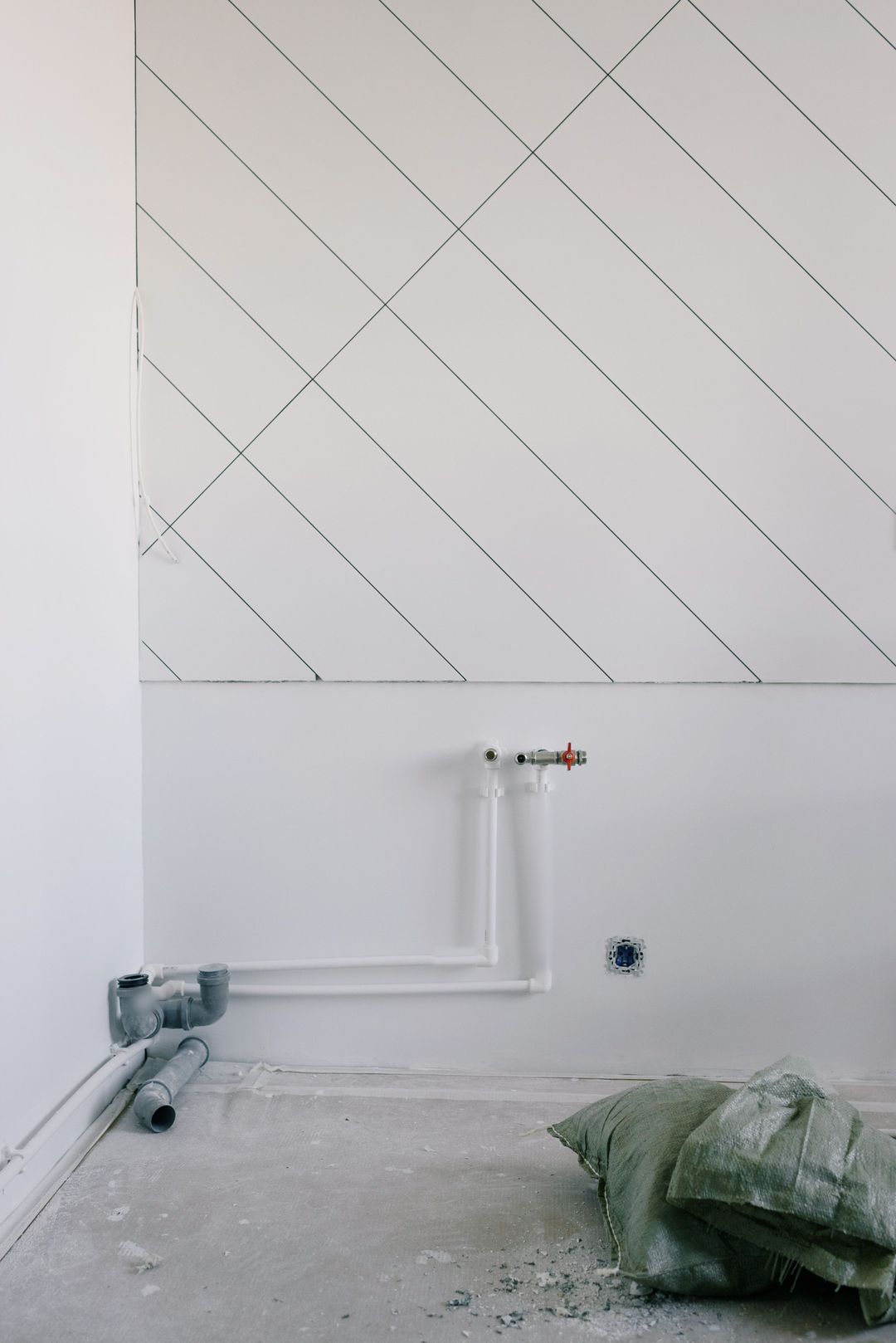 Ein Bad im Rohbau: an der Wand die Anschlüsse für Waschtisch und Dusche