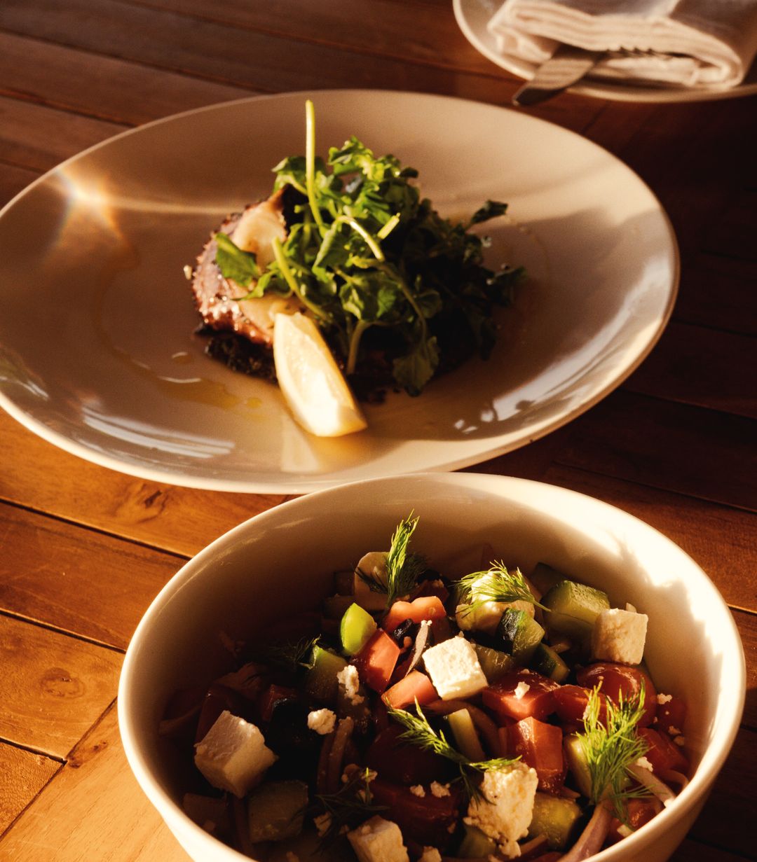 Zwei Schalen mit Salat aus Bohnen, Tomaten und Käse auf einem Holztisch